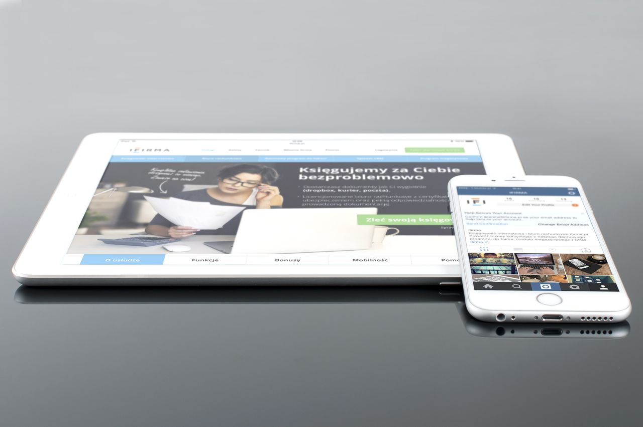 gallery-05 A modern tablet and smartphone showing web content on a reflective surface, emphasizing technology and connectivity.